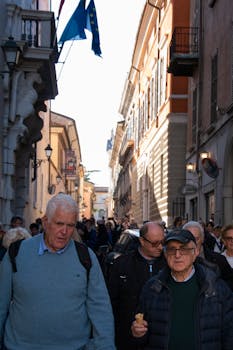 Crowded street in Brescia, Italy, bustling with tourists and locals on a sunny day.